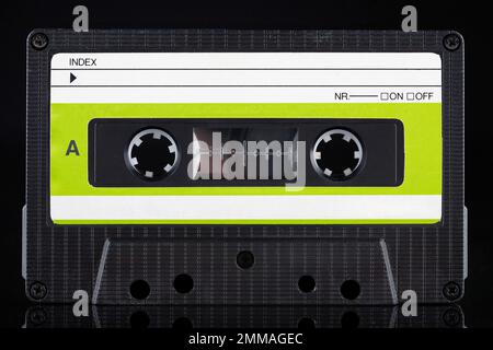 Cassetta compatta vintage retro a con etichetta verde - lato su sfondo nero Foto Stock