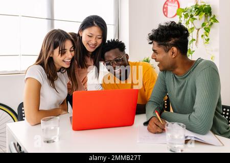 Un gruppo di allegri studenti millenari studia insieme a casa. Foto Stock