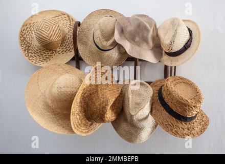 Rack stipato con cappelli in fibre vegetali. Stile country Foto Stock