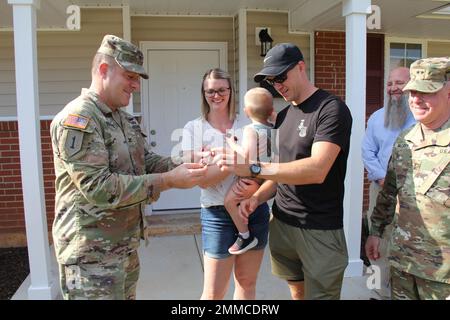 Robert J. Holcombe, comandante della guarnigione di Fort Rucker, consegna le chiavi della nuova casa della famiglia Wise a Fort Rucker al personale Sgt. Jared Wise e sua moglie, Tiffani, come generale maggiore Michael C. McCurry, USAACE e generale comandante Fort Rucker, guarda il 16 settembre 2022. La casa è l'ultima di 108 residenze recentemente rinnovate nel quartiere Munson Heights sul posto. Saggio recentemente è arrivato a Fort Rucker per frequentare il candidato ufficiale di garanzia e la scuola di volo. Foto di Jay Mann. Foto Stock