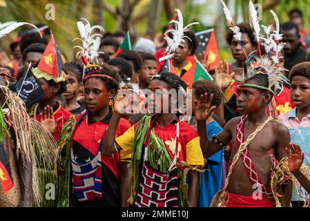 I bambini alzano la mano destra durante la riproduzione dell'inno nazionale del Papuan al villaggio di Banak, Papua Nuova Guinea, 16 settembre 2022. Il villaggio di Banak ha riunito una celebrazione nella Giornata dell'Indipendenza di Papua Nuova Guinea in memoria del 1st. Il Lt. Gabriel J. Eggud, i cui resti sono stati rinvenuti e resi conto in una missione di recupero nel 2019. La missione di DPAA è quella di ottenere la contabilità più completa possibile per il personale degli Stati Uniti mancante e non contabilizzato per le loro famiglie e la nostra nazione. Foto Stock