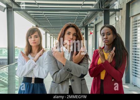 Tre donne con le braccia incrociate sostengono il movimento Break the Bias per la Giornata internazionale della donna Foto Stock