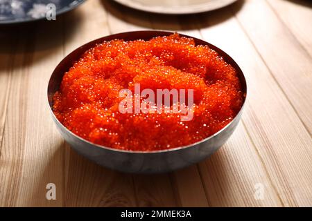 Caviale fresco rosso in ciotola su tavolo di legno Foto Stock