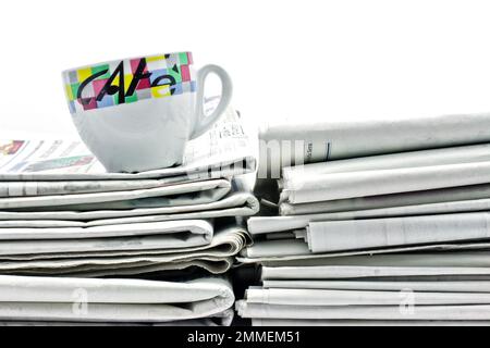 Pila di nuovi giornali con una tazza di caffè su di loro per la vostra colazione di mattina Foto Stock