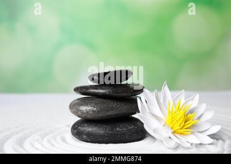 Giardino Zen. Bel fiore di loto e pietre su sabbia bianca Foto Stock