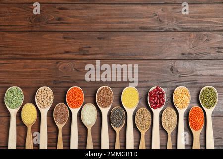 Composizione piatta con diversi tipi di legumi e cereali su tavola di legno, spazio per il testo. Grani organici Foto Stock