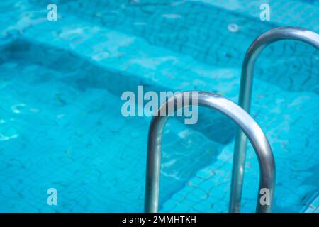 Scala con barre di appoggio in piscina. Vista ravvicinata, spazio di copia. Foto Stock