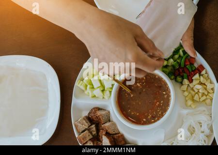 Primo piano con salsa per involtini di polpette vietnamite (Nam-Neung), involtini di salsiccia di maiale con verdure fresche in carta di riso, generoso piatto con cui mangiare Foto Stock