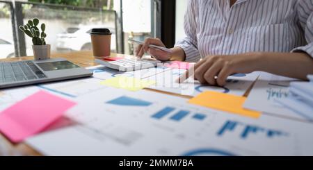 Financial Businesswomen analizza il grafico delle prestazioni dell'azienda per creare profitti e crescita, le relazioni di ricerche di mercato e le statistiche sul reddito Foto Stock