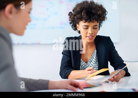 Scelta di una combinazione di colori per completare il suo progetto. due designer che guardano i campioni di colore. Foto Stock