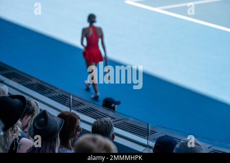 Folle che guardano una atleta professionista giocatore di tennis che gioca su un campo in un torneo di tennis in estate Foto Stock