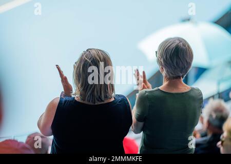 Folle che guardano una atleta professionista giocatore di tennis che gioca su un campo in un torneo di tennis in estate Foto Stock