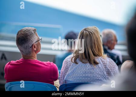 Folle che guardano una atleta professionista giocatore di tennis che gioca su un campo in un torneo di tennis in estate Foto Stock