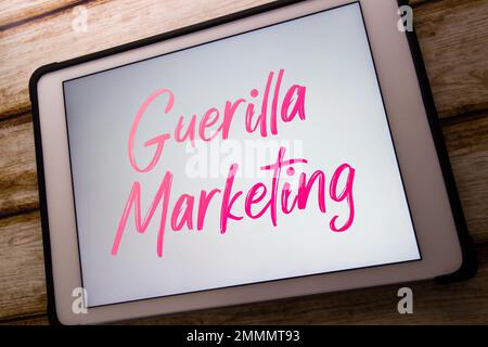 La parola chiave "Guerrilla Marketing" viene visualizzata sul tablet. Strategia pubblicitaria a sorpresa o interazioni non convenzionali per promuovere il concetto di prodotto o servizio Foto Stock