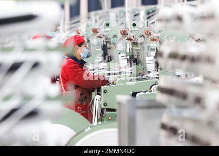 SUQIAN, CINA - 30 GENNAIO 2023 - Un lavoratore si precipita a fare ordini per le esportazioni verso paesi lungo la cintura e la strada in una fabbrica di maglieria e imballaggio Foto Stock