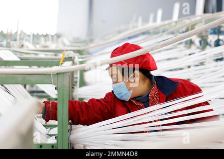 SUQIAN, CINA - 30 GENNAIO 2023 - Un lavoratore si precipita a fare ordini per le esportazioni verso paesi lungo la cintura e la strada in una fabbrica di maglieria e imballaggio Foto Stock