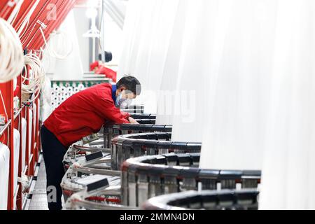 SUQIAN, CINA - 30 GENNAIO 2023 - Un lavoratore si precipita a fare ordini per le esportazioni verso paesi lungo la cintura e la strada in una fabbrica di maglieria e imballaggio Foto Stock