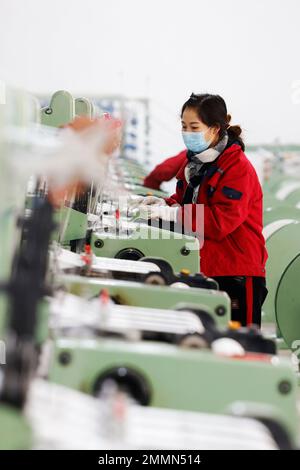 SUQIAN, CINA - 30 GENNAIO 2023 - Un lavoratore si precipita a fare ordini per le esportazioni verso paesi lungo la cintura e la strada in una fabbrica di maglieria e imballaggio Foto Stock