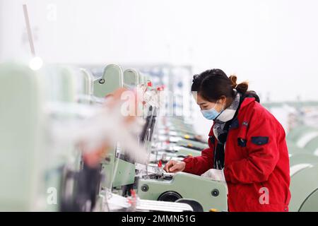 SUQIAN, CINA - 30 GENNAIO 2023 - Un lavoratore si precipita a fare ordini per le esportazioni verso paesi lungo la cintura e la strada in una fabbrica di maglieria e imballaggio Foto Stock