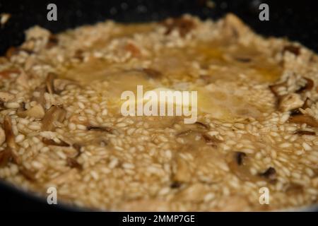 Processo di cottura del risotto. Riso Arborio in padella in cucina casalinga. Piatto di cucina italiana Foto Stock