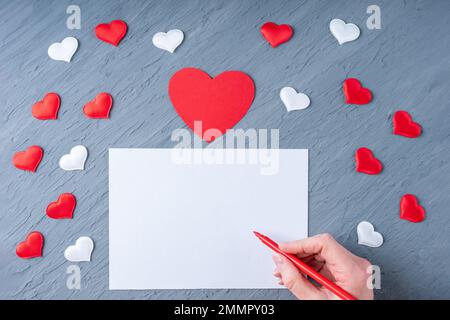 Carta regalo per il giorno di San Valentino con la penna e i petali a forma  di cuore, su sfondo di legno Foto stock - Alamy