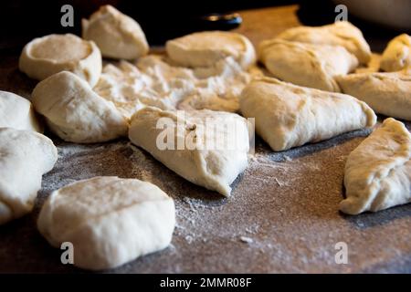 Friggete deliziose torte fatte in casa con carne ripieno di olio vegetale caldo. Le torte vengono fritte in una padella. Cucina russa. Foto Stock