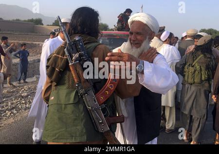 FILE - In this June 16, 2018 file photo, Taliban fighters gather with residents to celebrate a three-day cease fire marking the Islamic holiday of Eid al-Fitr, in Nangarhar province, east of Kabul, Afghanistan. On Sunday, Aug. 19, 2018, Afghan President Ashraf Ghani announced a conditional cease-fire with Taliban insurgents for the duration of the Eid al-Adha holiday. Ghani made the announcement Sunday during celebrations of the 99th anniversary of Afghanistan's independence. (AP Photo/Rahmat Gul, File)