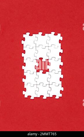 Puzzle bianchi su sfondo rosso, piatto. Foto Stock