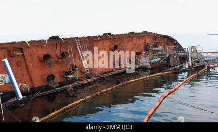 Vecchia petroliera arrugginita che si trova sul suo bordo nelle acque poco profonde. Affondata nave annegata dopo il relitto. Foto Stock