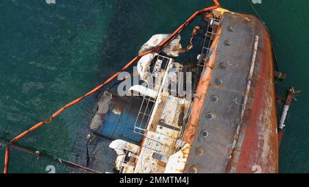 Vista dall'alto della vecchia e arrugginita nave petroliera rovesciata dopo il relitto. Annegata nave affondata in acque poco profonde. Foto Stock