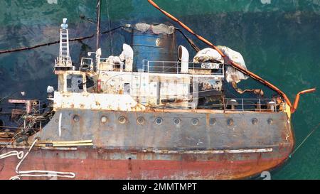 Vista aerea dall'alto di una nave petrolifera rotta rovesciata dopo il relitto. Annegata nave affondata in acque poco profonde. Foto Stock