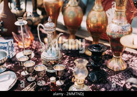 Caraffa orientale in metallo con motivo floreale in tessuto inciso. Caraffa antica in stile orientale al mercato delle pulci. Tavola Est. Vecchio vasellame per tè e caffè Foto Stock