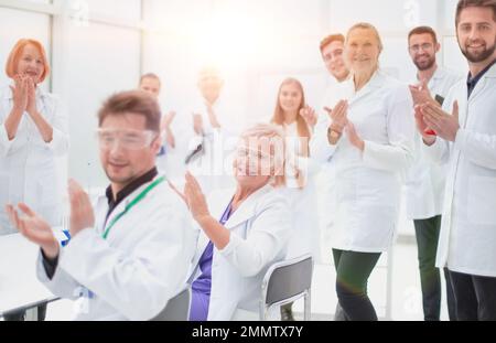 gruppo di giovani scienziati che si congratulano con il collega con applausi. concetto di successo Foto Stock