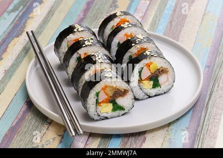 Gimbap è un cibo coreano composto da riso e diversi ingredienti conditi con olio di sesamo e avvolti in nori alghe. Foto Stock