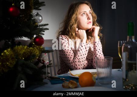 La ragazza si annoia e bevendo champagne nel nuovo anno vicina Foto Stock