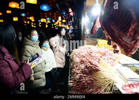 Enshi, Provincia cinese di Hubei. 29th Jan, 2023. La gente compra i kebab in un punto panoramico nella contea di Xuan'en, provincia di Hubei della Cina centrale, 29 gennaio 2023. La contea di Xuan'en ha costruito sentieri, fontane e cabine per spuntini lungo il fiume Gongshui per aumentare l'economia notturna. Credit: Canzone Wen/Xinhua/Alamy Live News Foto Stock