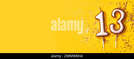 Le candele d'oro nella forma di numero tredici. Foto Stock