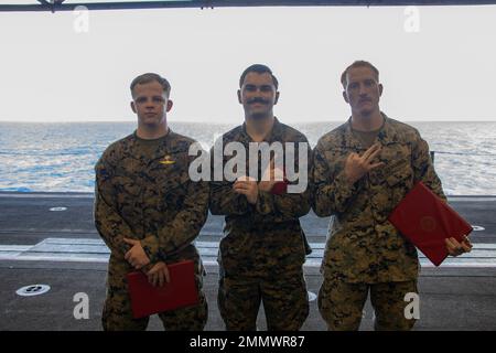 I primi tre finitori di un torneo di combattimento a terra del Marine Corps Martial Arts Program posano per una fotografia di gruppo a bordo della nave d'assalto anfibio USS Tripoli (LHA-7), nel Mare delle Filippine, 23 settembre 2022. U.S. Navy Hospital Corpsman 3rd Class Jonathon Kazarian, un corpsman assegnato a Golf Company, Battalion Landing Team 2/5, 31st Marine Expeditionary Unit, ha vinto il primo posto, U.S. Marine Corps CPL. Jack Gaines, un Marine assegnato al 31st MEU, ha vinto il secondo posto e Sgt. Christian Manon, un uomo di fanteria assegnato a Golf Company, BLT 2/5, 31st MEU, ha vinto il terzo posto. Il torneo si è tenuto il t Foto Stock