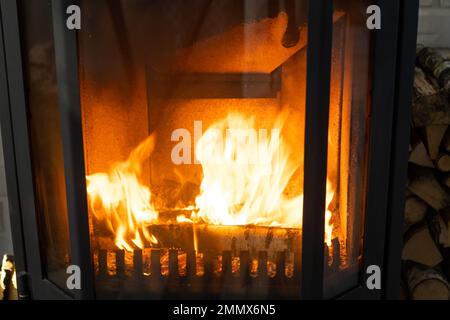 Legna da ardere sta bruciando nel forno del primo piano del focolare. Riscaldamento ecologico alternativo, camera calda e accogliente a casa, legna da ardere Foto Stock