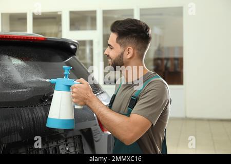 Spruzzare acqua sul finestrino dell'auto prima di colorare Foto Stock