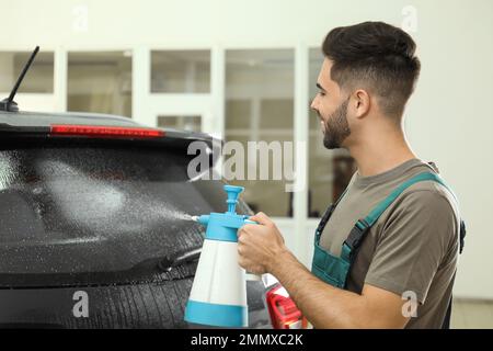 Spruzzare acqua sul finestrino dell'auto prima di colorare Foto Stock