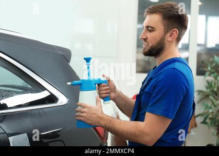 Spruzzare acqua sul finestrino dell'auto prima di colorare Foto Stock