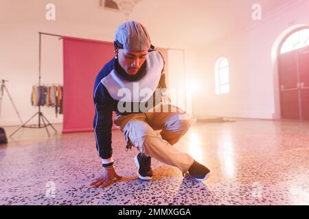 Immagine della ballerina biraciale maschile hip hop in studio. Danza, ritmo, movimento e concetto di allenamento. Foto Stock