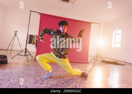 Immagine della ballerina biraciale maschile hip hop in studio. Danza, ritmo, movimento e concetto di allenamento. Foto Stock