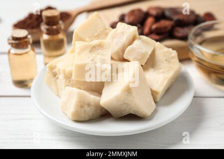 Burro di cacao biologico su tavola di legno, primo piano Foto Stock