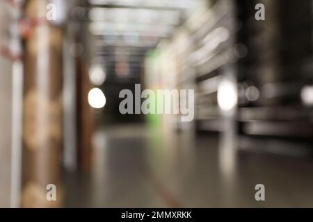 Vista sfocata dei supporti di stoccaggio con materiali da costruzione diversi nel magazzino all'ingrosso Foto Stock