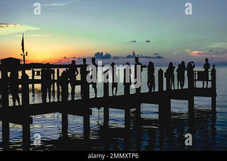 Silhouette persone sul lungomare dopo cena e cocktail guardando il tramonto in Marathon Key, Fl. in una bella serata estiva nel mese di agosto 2017. Foto Stock