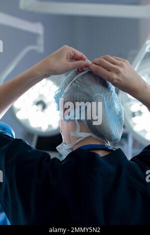 Chirurgo caucasico in sala operatoria, con maschera facciale Foto Stock