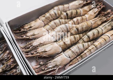 Pacchetto con gamberetti freschi neri, primo piano. Mercato all'ingrosso Foto Stock