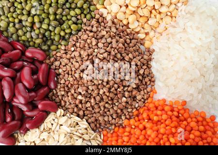 Diversi tipi di legumi e cereali come sfondo, vista dall'alto. Grani organici Foto Stock